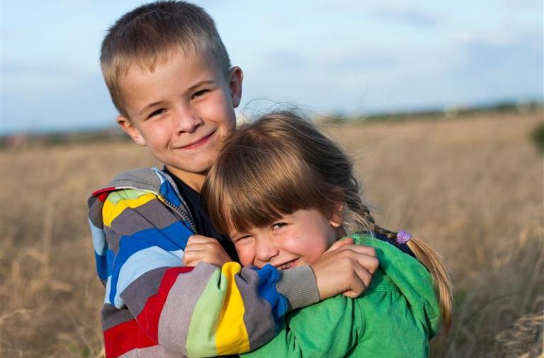 siblings playing together in a field