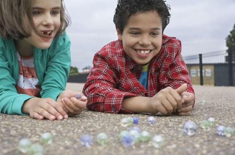 siblings playing marbles game